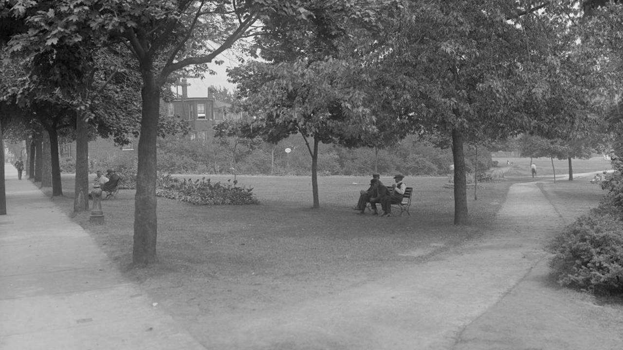 An image of people sitting on a bench in Bellwoods Park in 1930