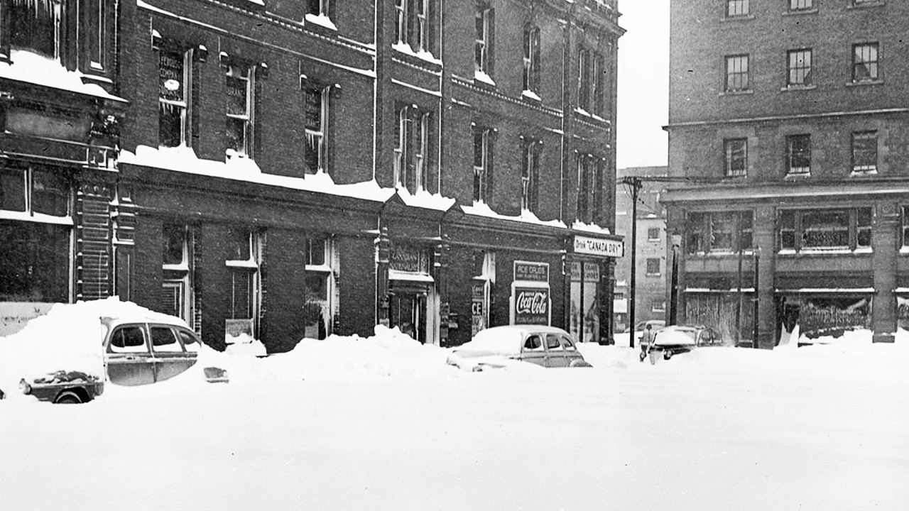 A black and white archival photo of cars buried under deep snow in Toronto on Dec. 11, 1944