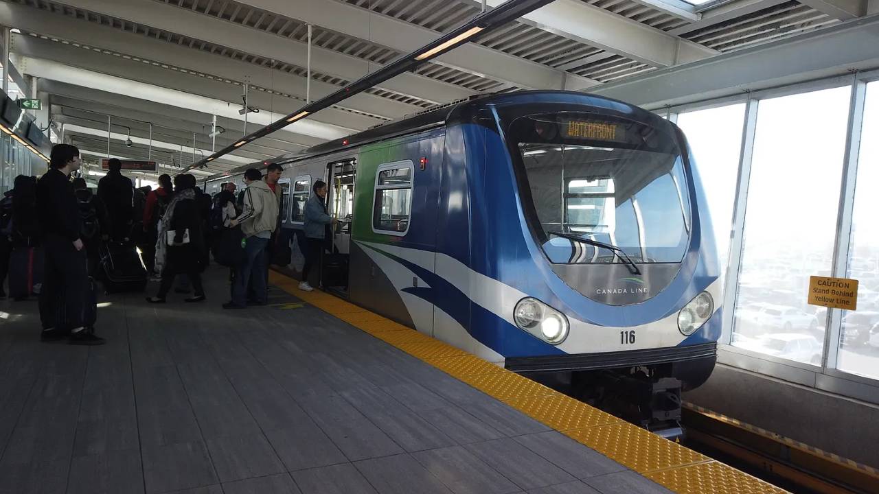 An image of a Canada Line Train boarding passengers at a station in Vancouver