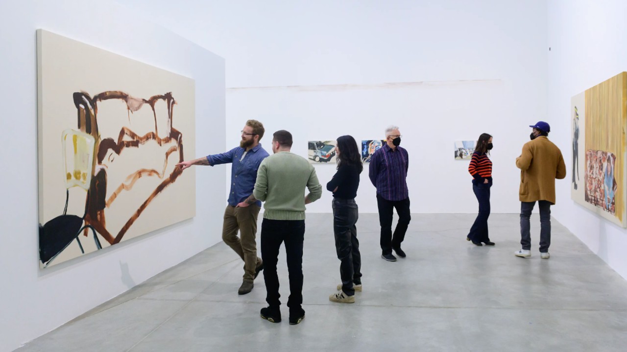 People check out paintings at Drink from the river, an art show in Toronto