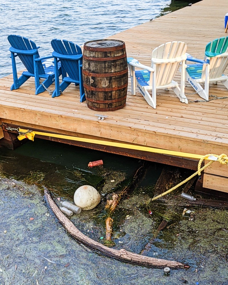 An image of a plastic bottle used for an experiment floating underneath a dock at Bathurst Quay in Toronto