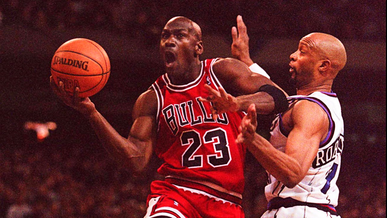 An image of Michael Jordan taking the ball to the hoop in an NBA game in 1996