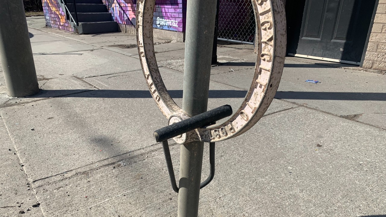 A forgotten bike lock hangs from a Toronto bicycle ring