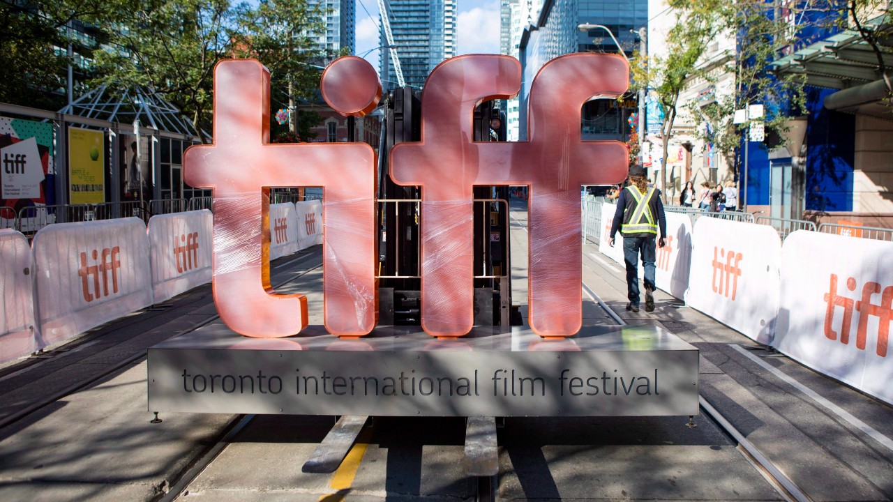 An image of a large light-up Toronto International Film Festival sign being moved on a fork lift on King St. in Toronto