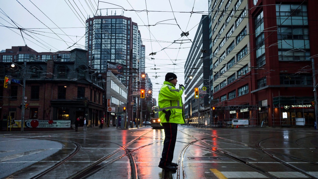 A Toronto police constable directs traffic at King St. W. and Bathurst St. during the King Street Transit Pilot