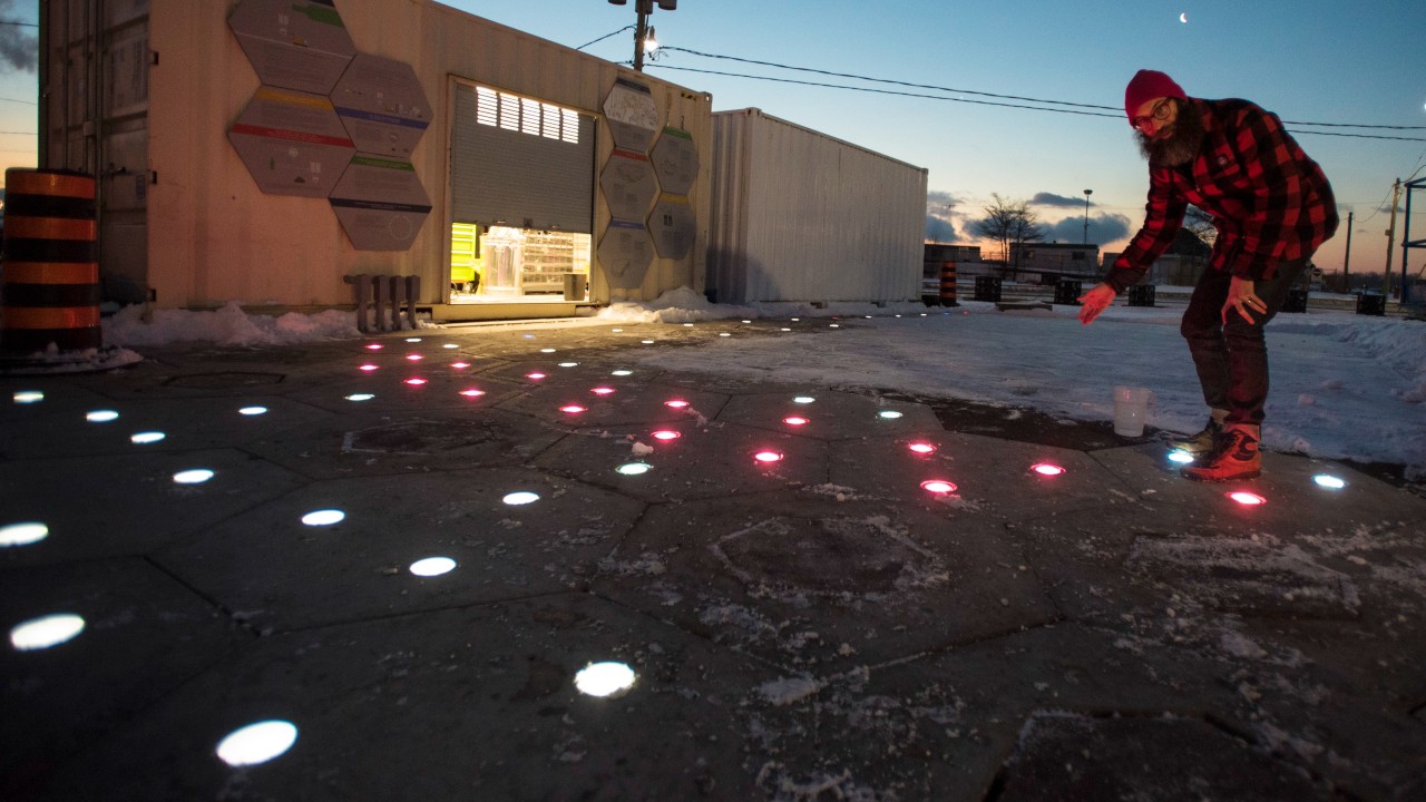A Sidewalk Labs employee showcases modular pavement with lights and porous slabs at a media event in March 2019