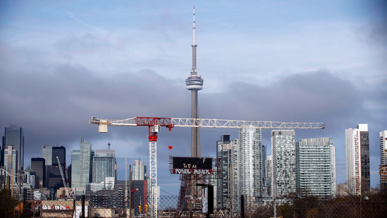 A view of the Toronto skyline, featuring a crane, the CN Tower, and several condominium buildings